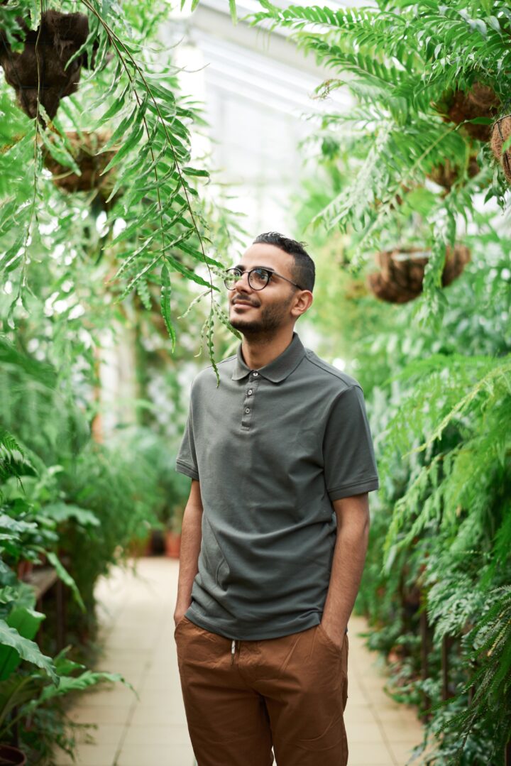 Bilden visar en man i ett växthus av trä. Det finns även olika tunnelväxthus och bågväxthus med polykarbonatskivor.
